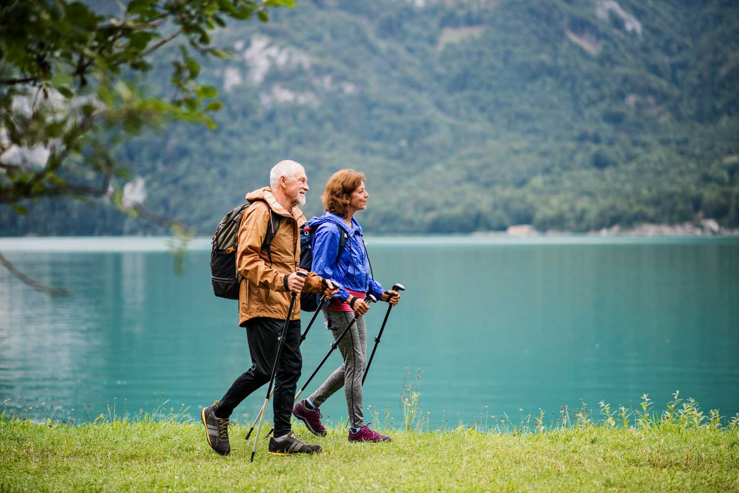 A Side View of Senior Pensioner Couple Hiking by Lake