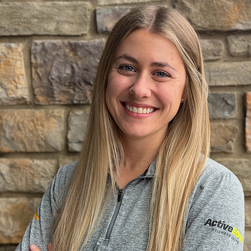 A woman with blond hair in front of a white background.