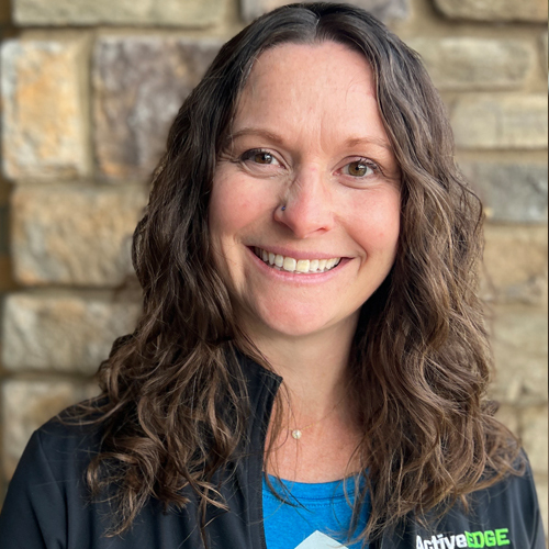 A woman with blond hair in front of a white background.