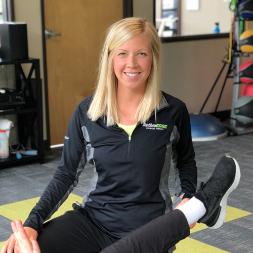 A woman with blond hair in front of a white background.