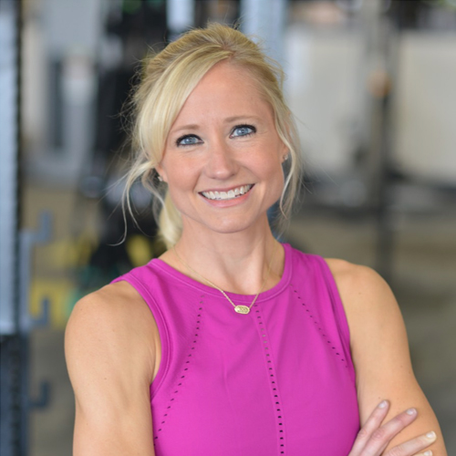 A woman with blond hair in front of a white background.