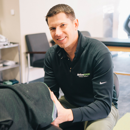 A woman with blond hair in front of a white background.