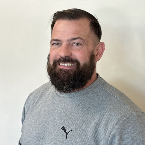 A woman with blond hair in front of a white background.