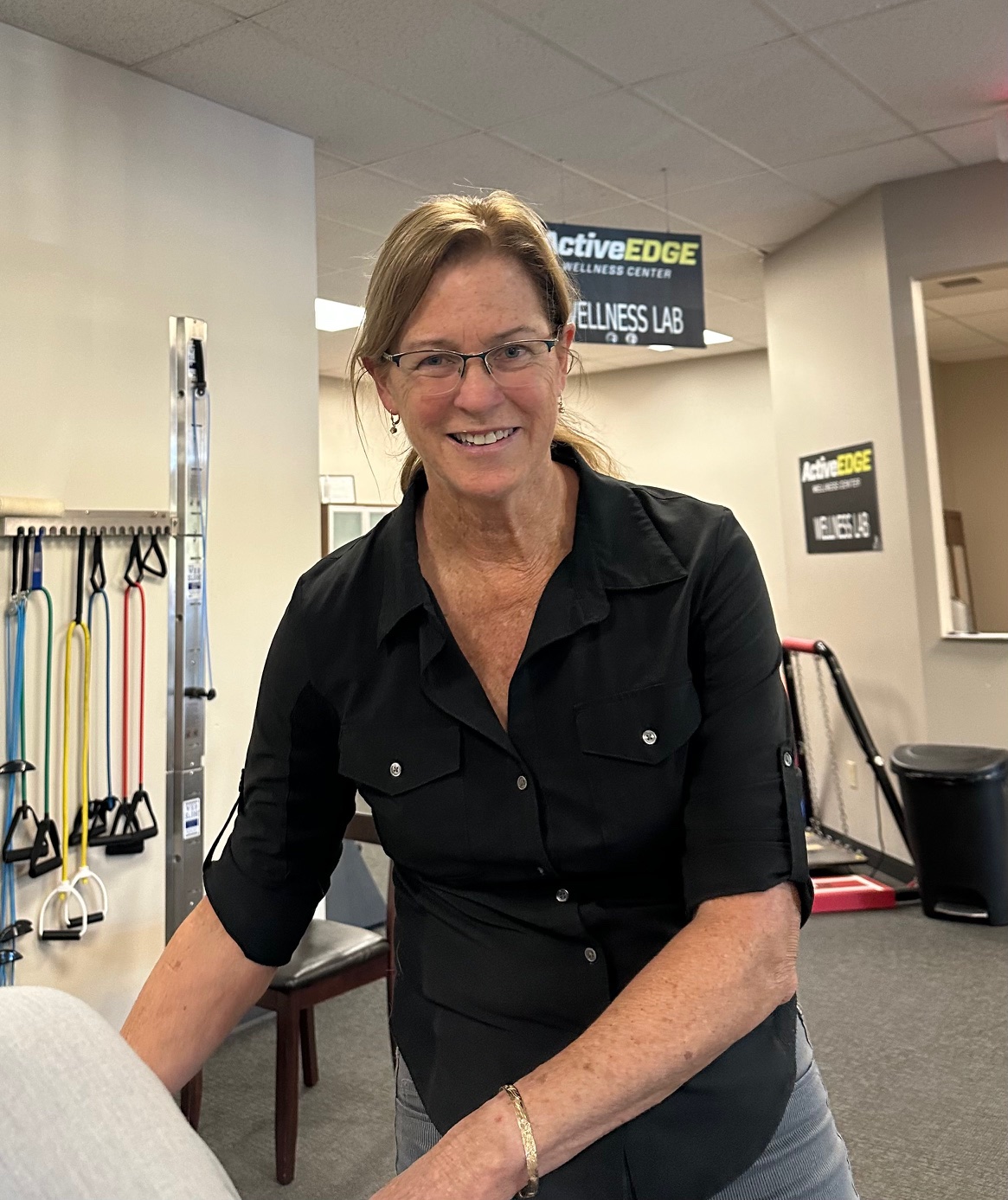 A woman with blond hair in front of a white background.